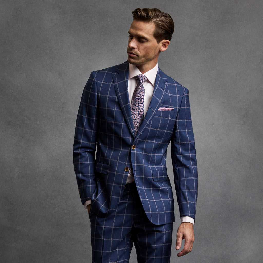Man wearing a blue checkered suit with a gray background