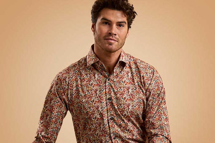 Man wearing a patterned Ganton shirt against a beige background