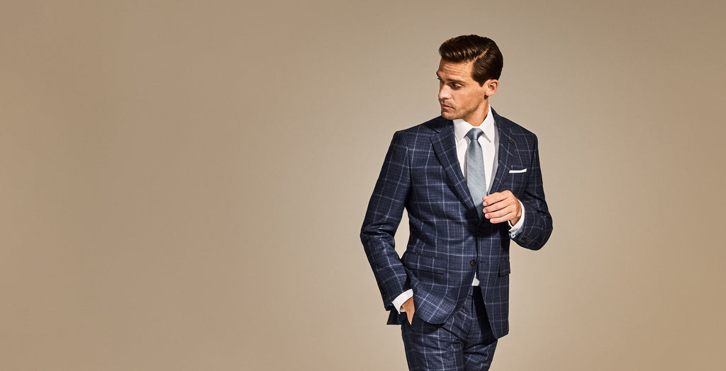 Man wearing a blue checkered suit on a beige background
